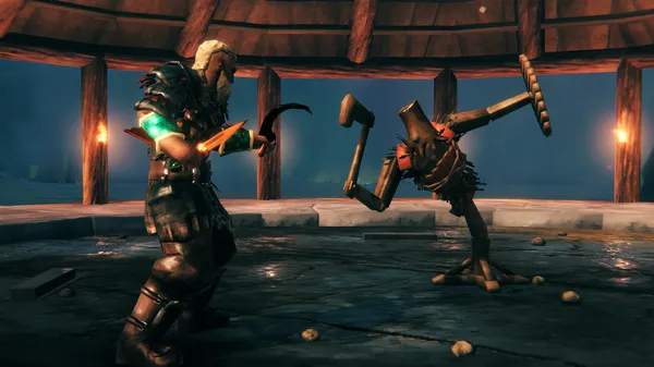 A Valheim warrior in heavy armor fighting a large troll enemy inside a torch-lit stone arena